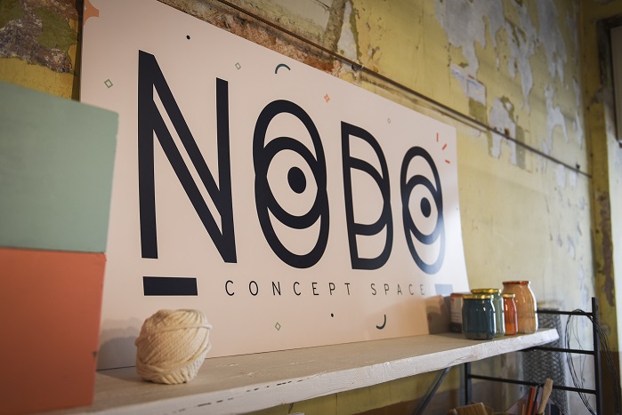 Immagine raffigurante il logo di Nodo con scorcio del locale dove ha sede il collettivo